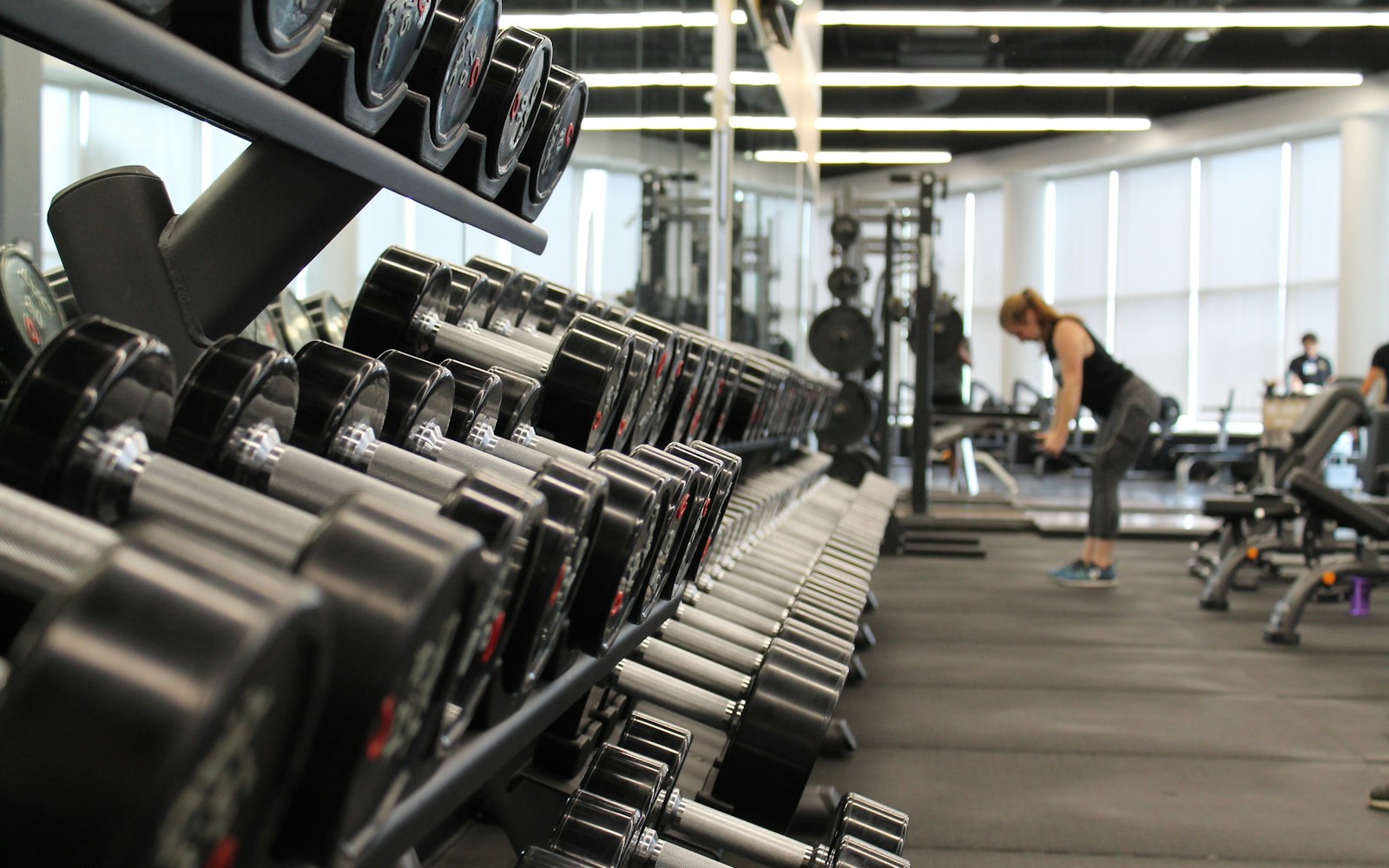 Athlete training hard beside a loaded barbell and stacked plates